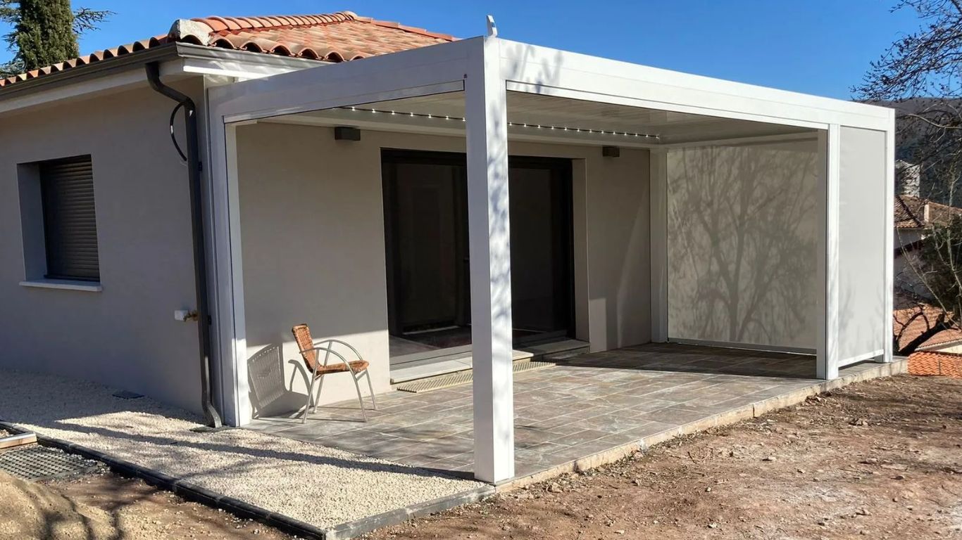 Pergola bioclimatique blanche IZI avec stores ZIP pour économies d'énergie dans l'Hérault